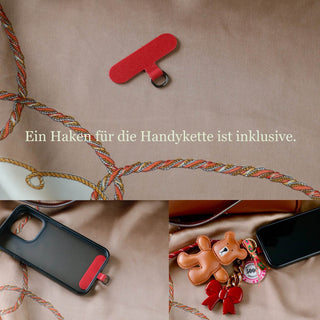 Brauner Teddy-Schlüsselanhänger mit roter Schleife und Pokerchip-Charms neben einer braunen Handtasche und einem Smartphone.