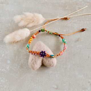 Handgefertigtes Makramee-Armband mit Smiley-Perle, bunten Miyuki-Perlen und kleinen Blumenanhängern in Orange, Grün und Rosa.