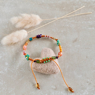 Handgefertigtes Makramee-Armband mit Smiley-Perle, bunten Miyuki-Perlen und kleinen Blumenanhängern in Orange, Grün und Rosa.