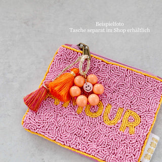 Kleine handbestickte Kosmetiktasche aus bunten Glasperlen mit gelber Grundfarbe, rosa Quaste und Reißverschluss – kompakte Mini-Tasche im Boho-Stil.