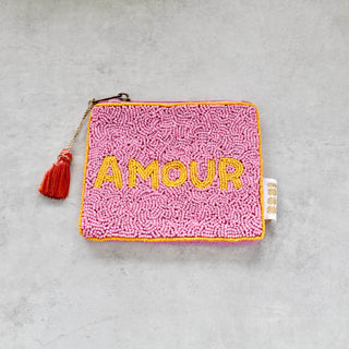 Kleine handbestickte Kosmetiktasche aus bunten Glasperlen mit gelber Grundfarbe, rosa Quaste und Reißverschluss – kompakte Mini-Tasche im Boho-Stil.