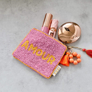 Kleine handbestickte Kosmetiktasche aus bunten Glasperlen mit gelber Grundfarbe, rosa Quaste und Reißverschluss – kompakte Mini-Tasche im Boho-Stil.