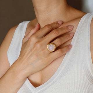 Offener, verstellbarer Ring aus Rosenquarz mit einem großen, runden, funkelnden Stein in warmer, matter Goldfarbe. Klobige Statement Ring